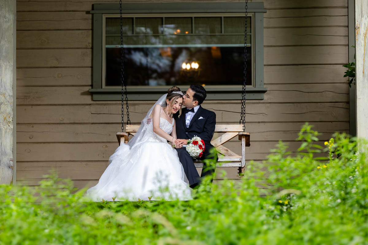 Sahar and Maziar embrace each other on a swing at Le Belvedere during a discrete wedding portrait, Quebec